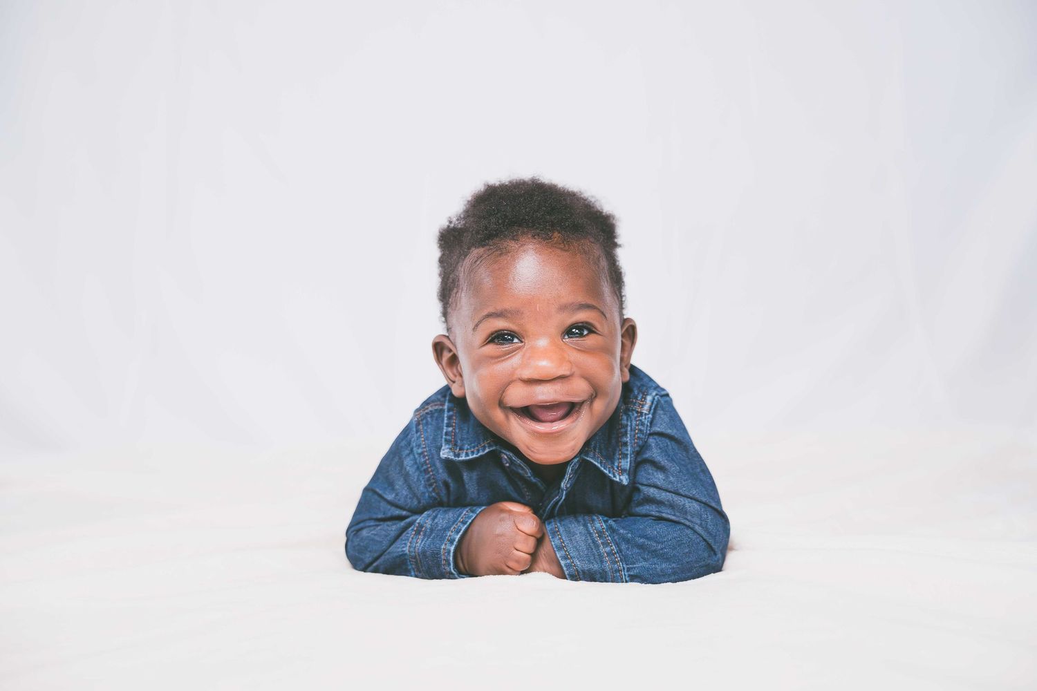 Child in blue denim jacket showing happy expressions in studio portraits.