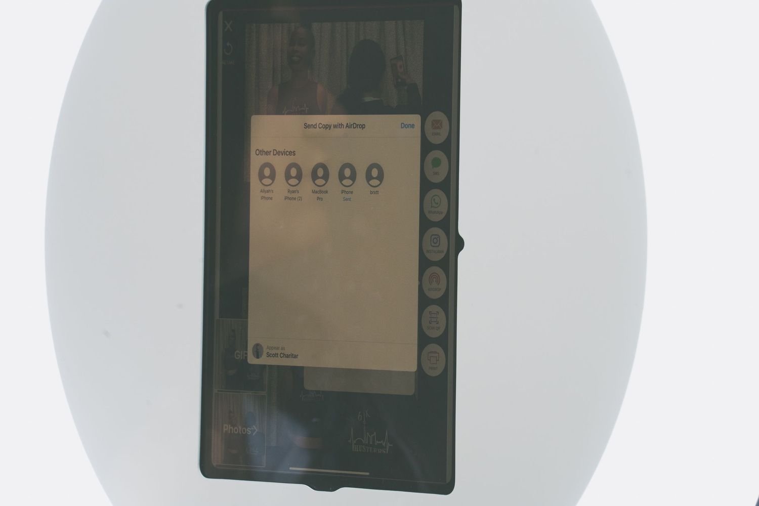 Electronic device screens displayed in circular white light projection.
