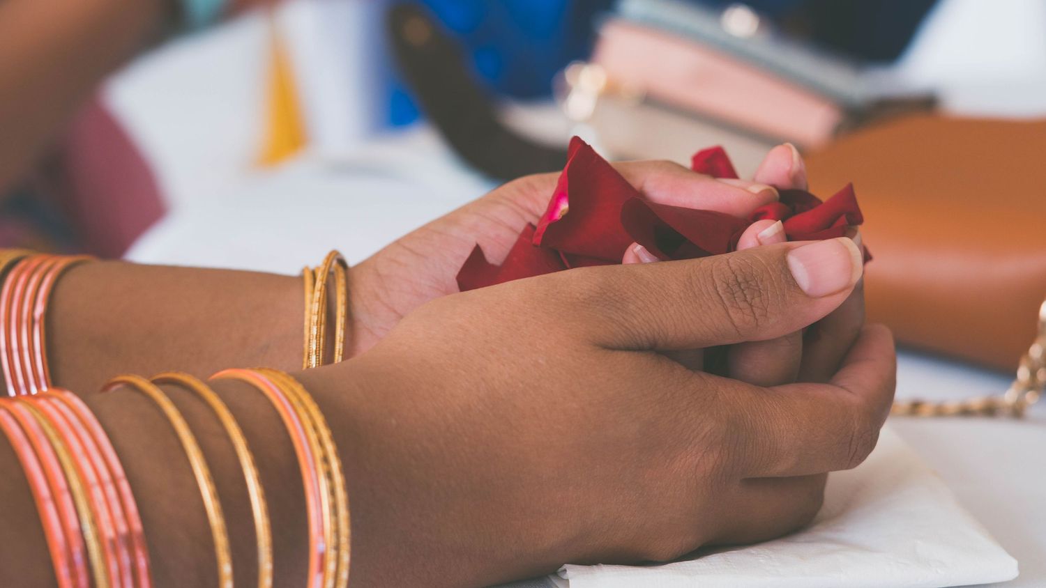 Close-up of hands holding mobile devices at a table.