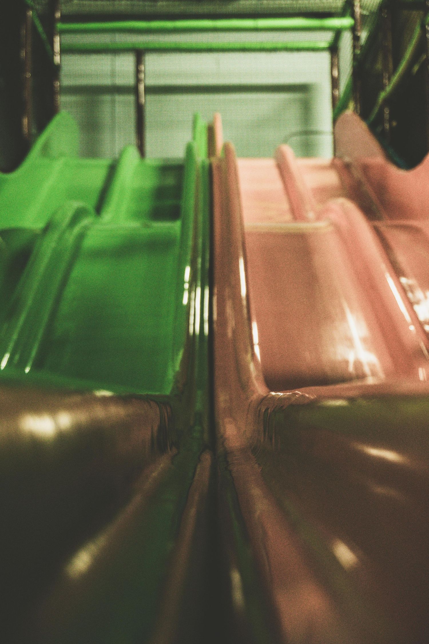 Green and pink neon lighting creates an atmospheric glow in an industrial space.
