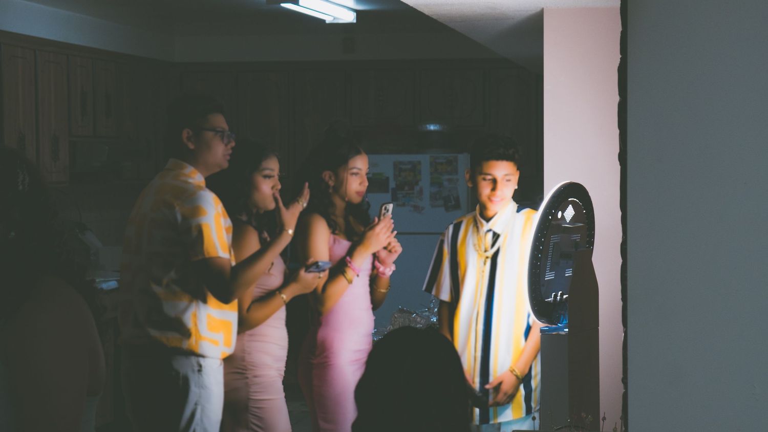 Dark indoor corridor with fluorescent lighting and blurred figures in the background.