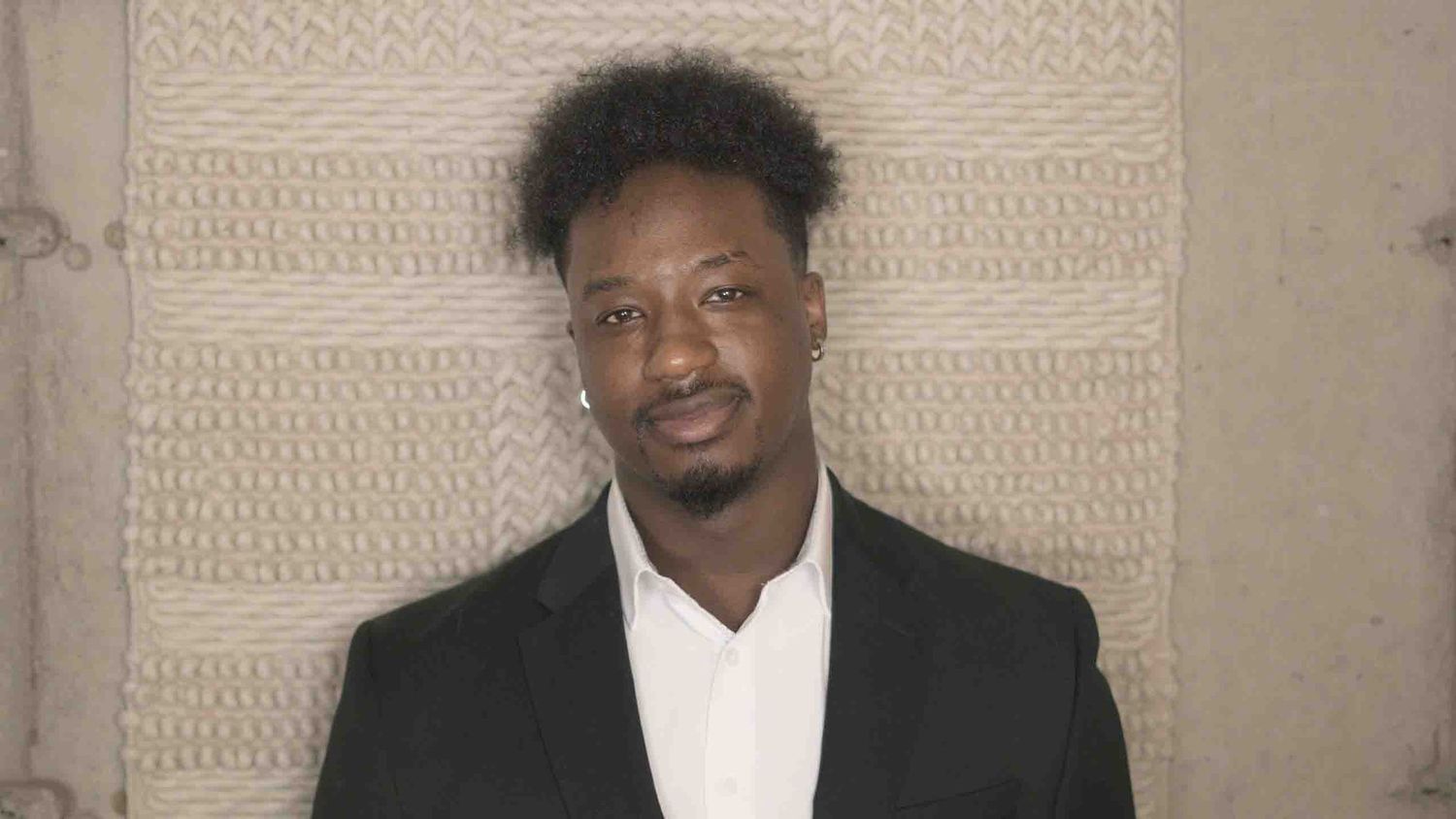 Studio portrait series with textured wall background.
