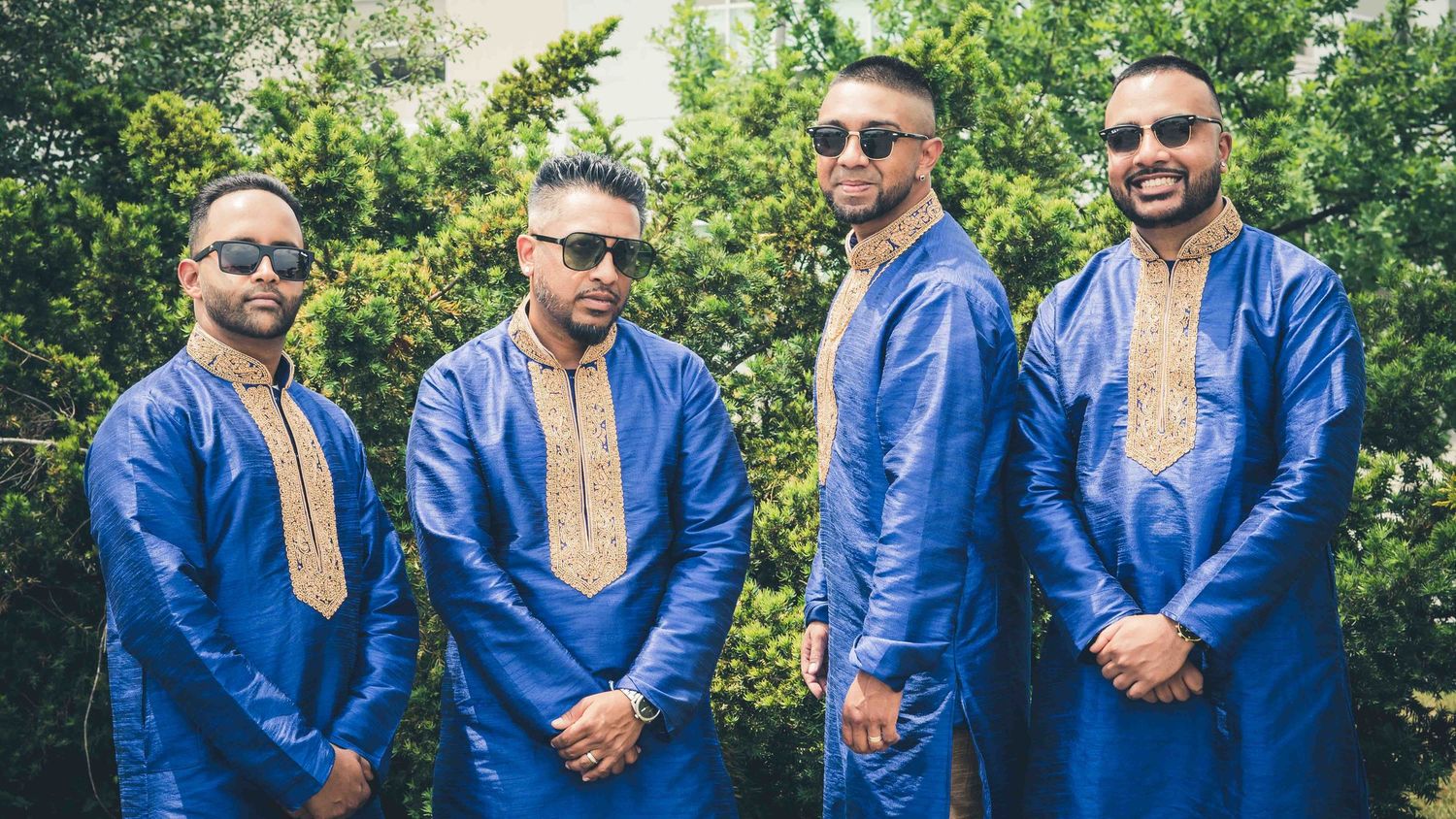 Group wearing coordinated royal blue traditional outfits standing together outdoors.