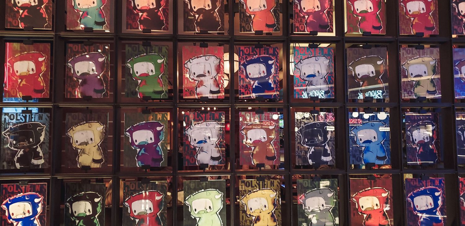 Collection of illuminated arcade game cabinets arranged in rows with colorful displays.