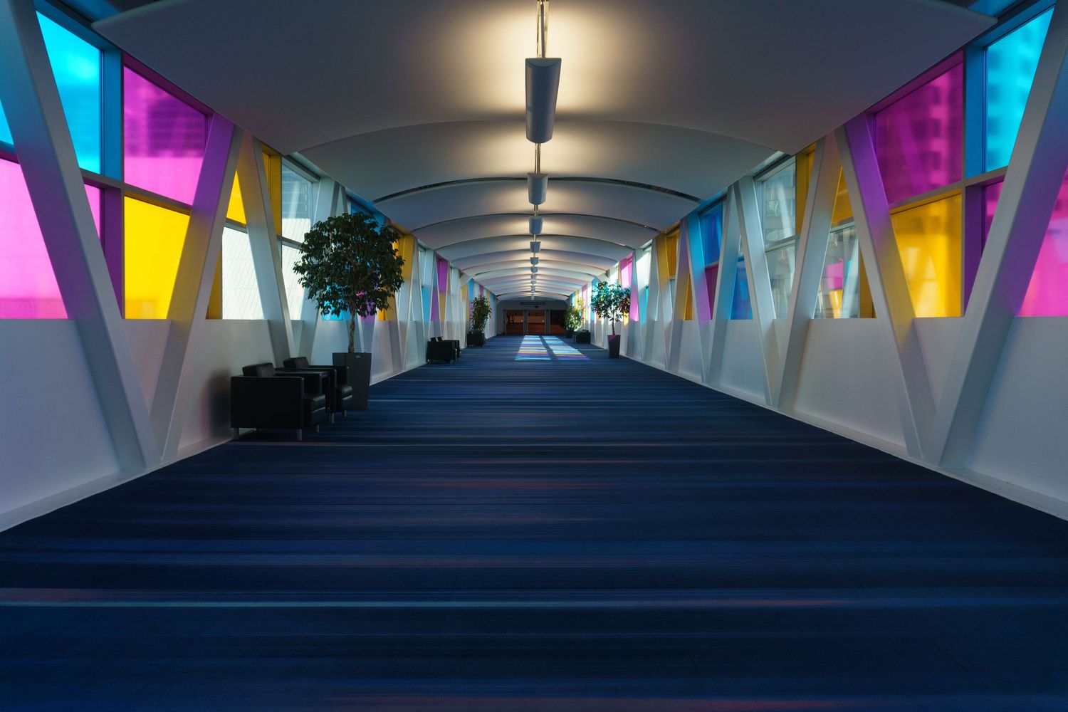 Long covered walkway decorated with colorful triangular flags and overhead lighting.