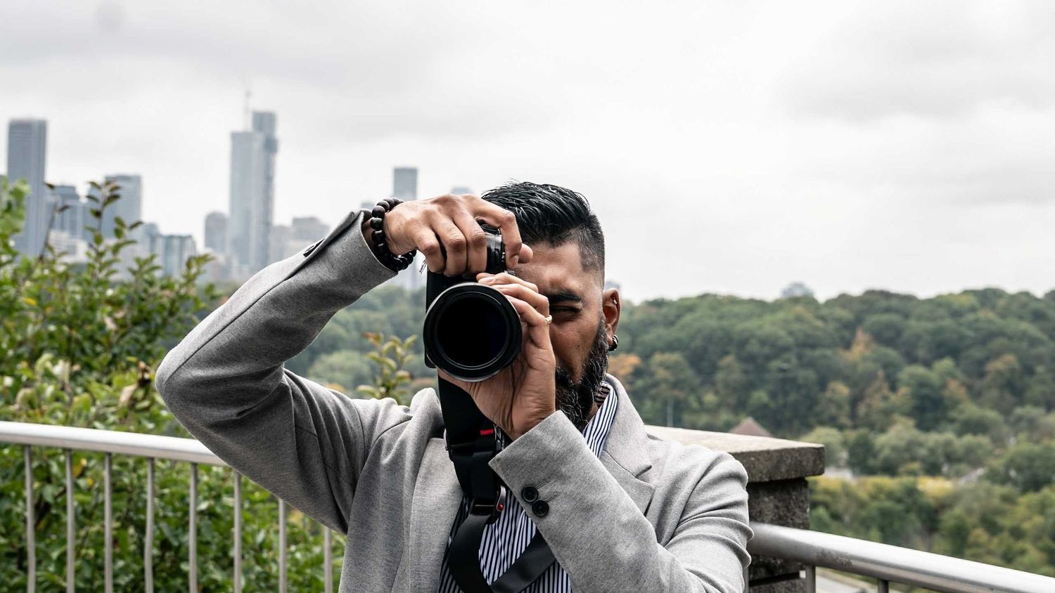 A series of photos showing someone taking pictures from a balcony overlooking a city skyline.