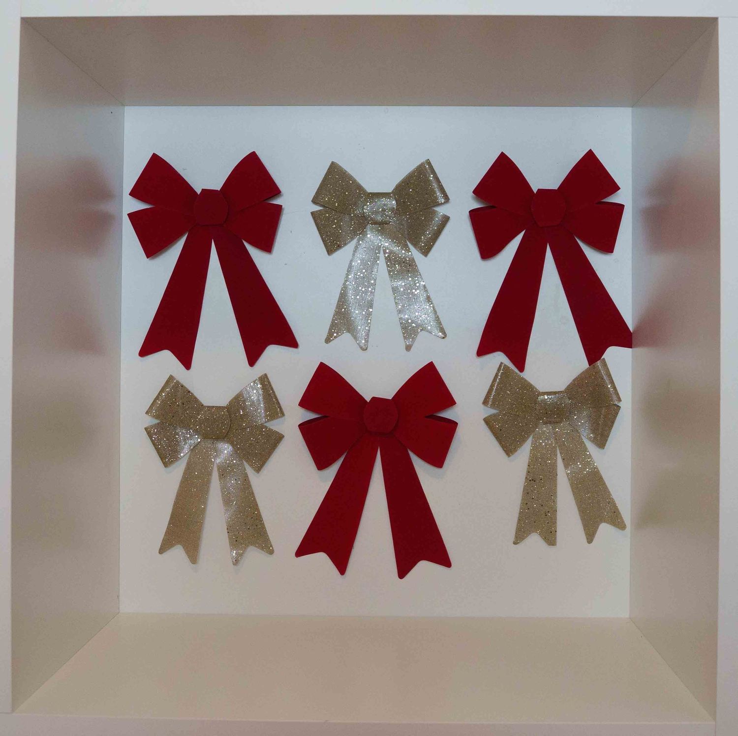 Red and gold decorative bows arranged in a row against a white background.