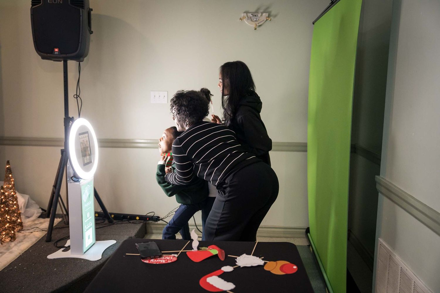 Photography setup with ring light and equipment in a studio with green wall.
