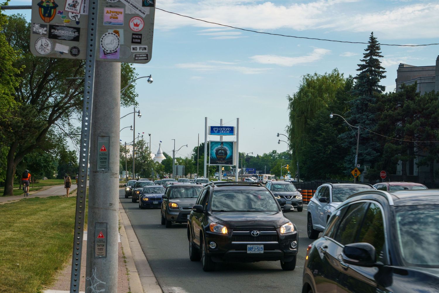 Suburban street view with cars parked along the roadside on a sunny day.