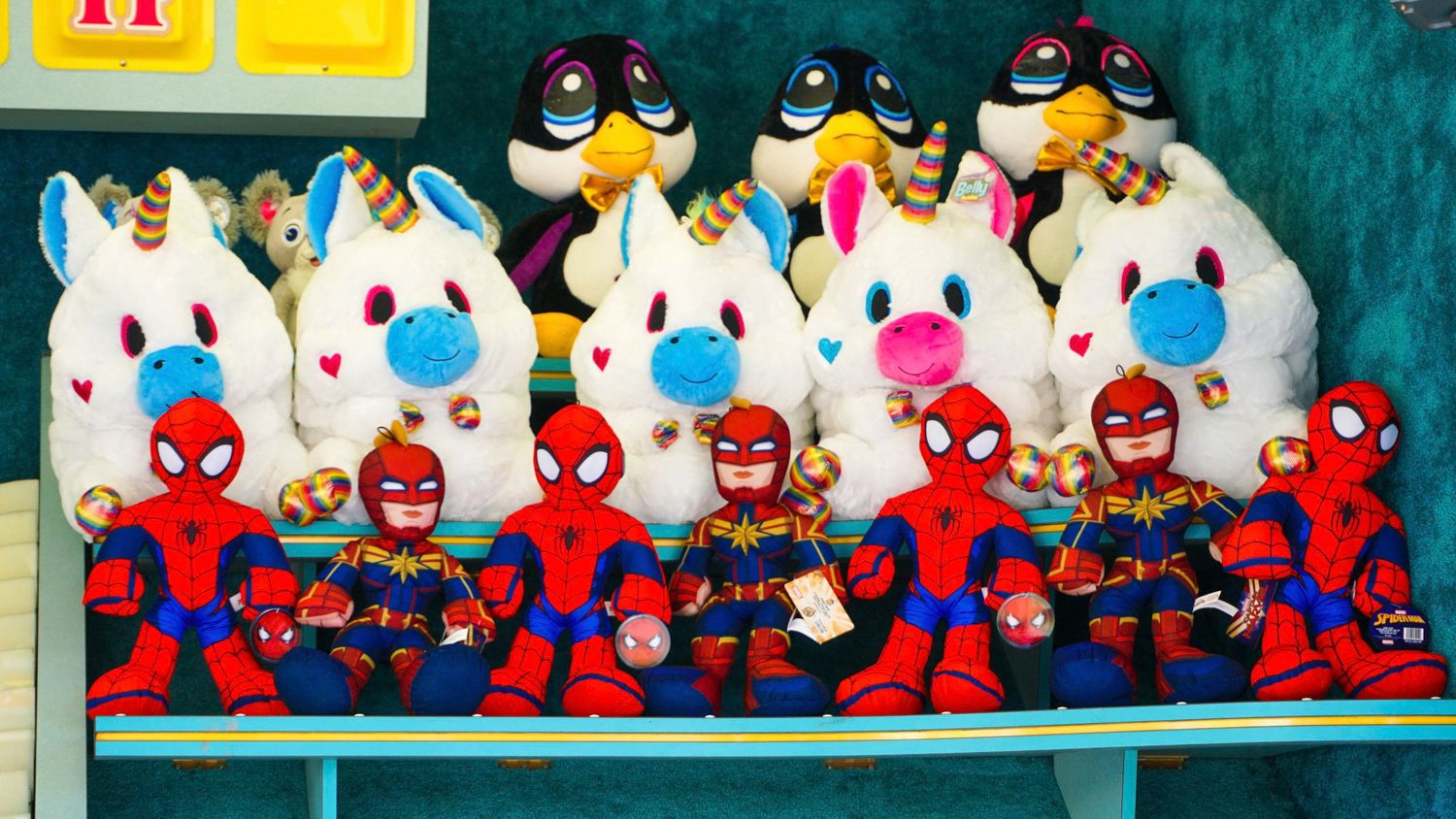 Colorful plush toys including Spider-Man and blue characters displayed on retail shelves.