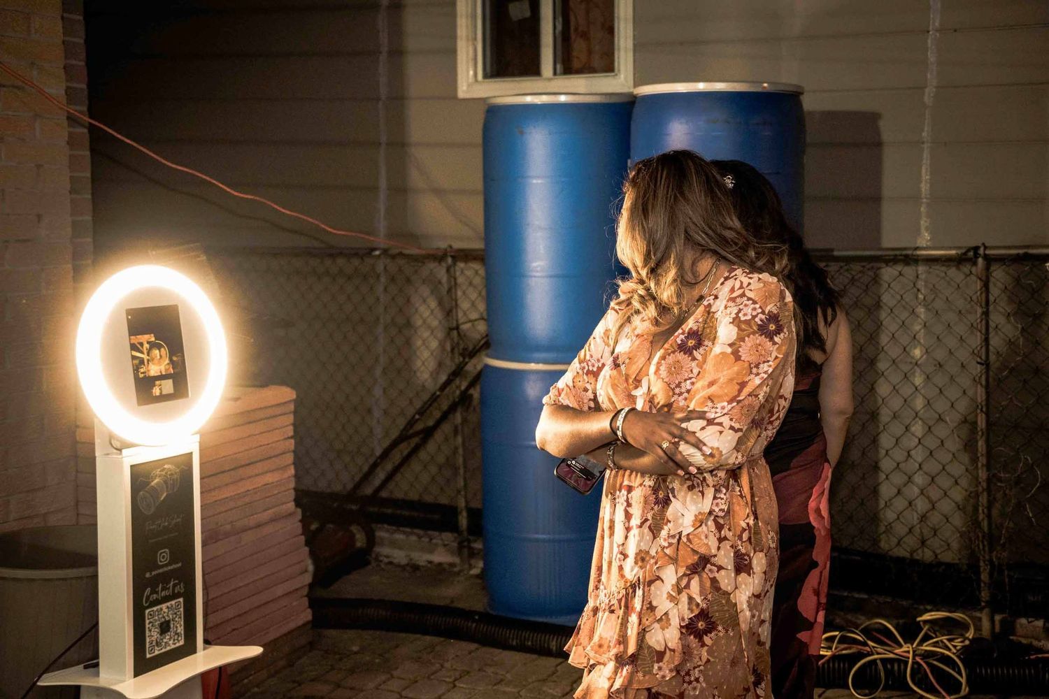 Ring light setup in dark room with blue storage containers visible in background.
