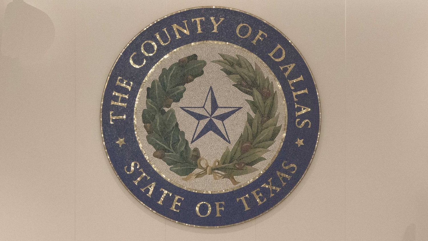 Official seal of Dallas County Texas featuring a lone star surrounded by a laurel wreath.
