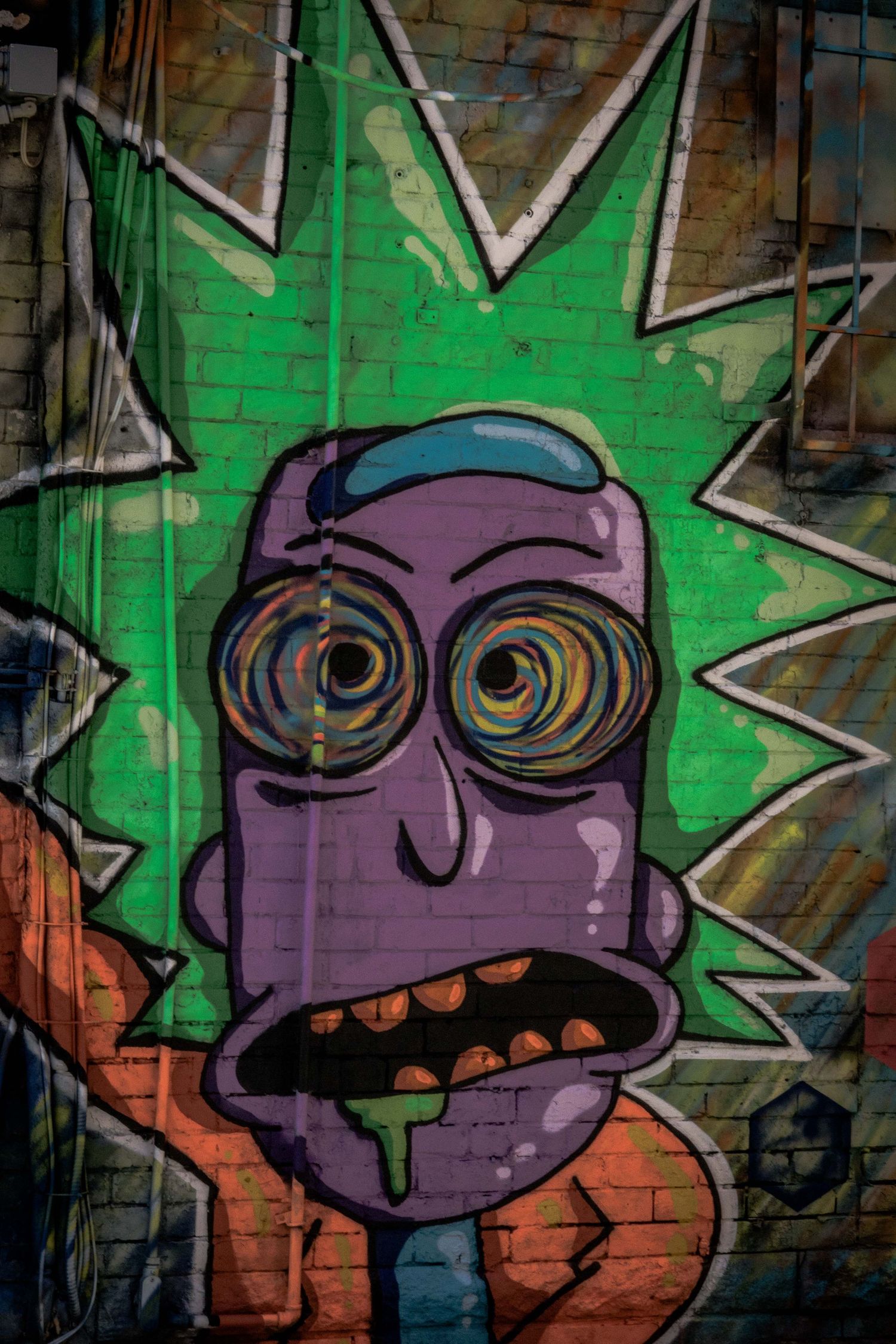 Street art mural featuring a purple cartoon character with glasses on a green background.