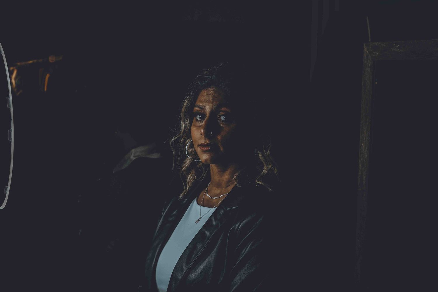 Close-up artistic portraits in dramatic low lighting showing emotional expressions.