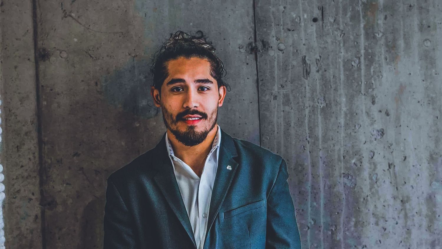 Professional portrait series showing different expressions against a concrete wall background.
