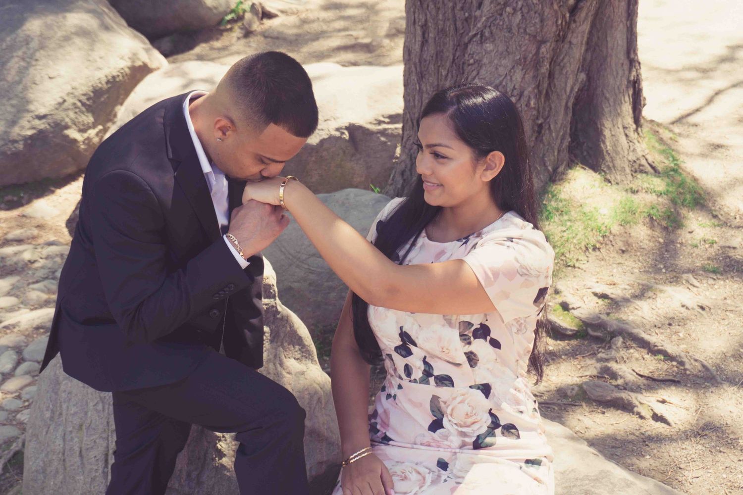 A romantic moment unfolds between a couple near a cherry blossom tree.