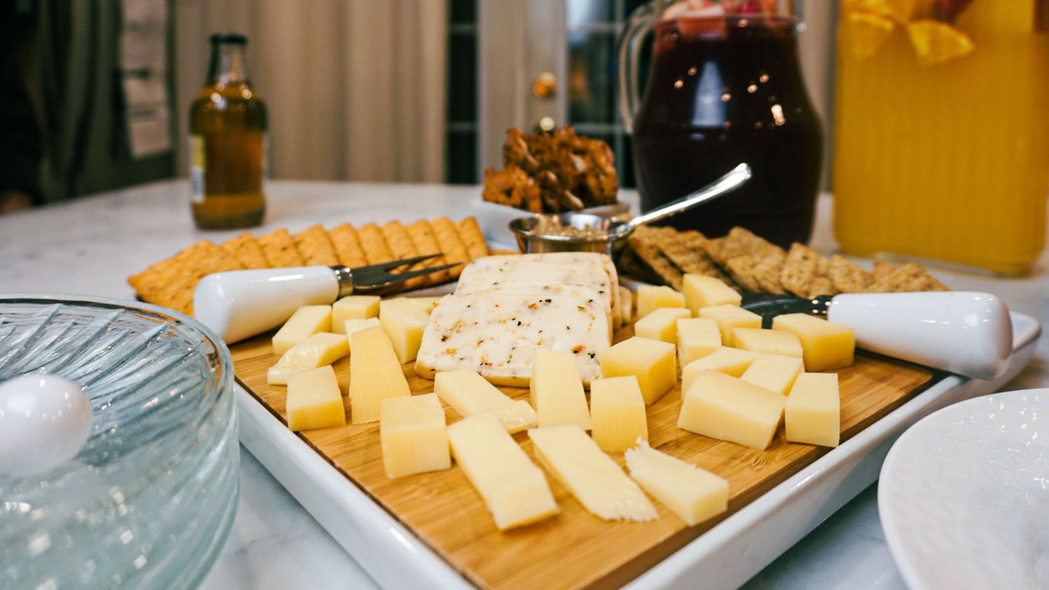 Close-up of cubed yellow cheese arranged on a white serving platter.