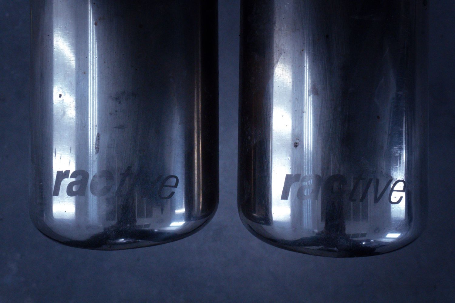 Row of glass containers with backlighting creating symmetrical shadows.