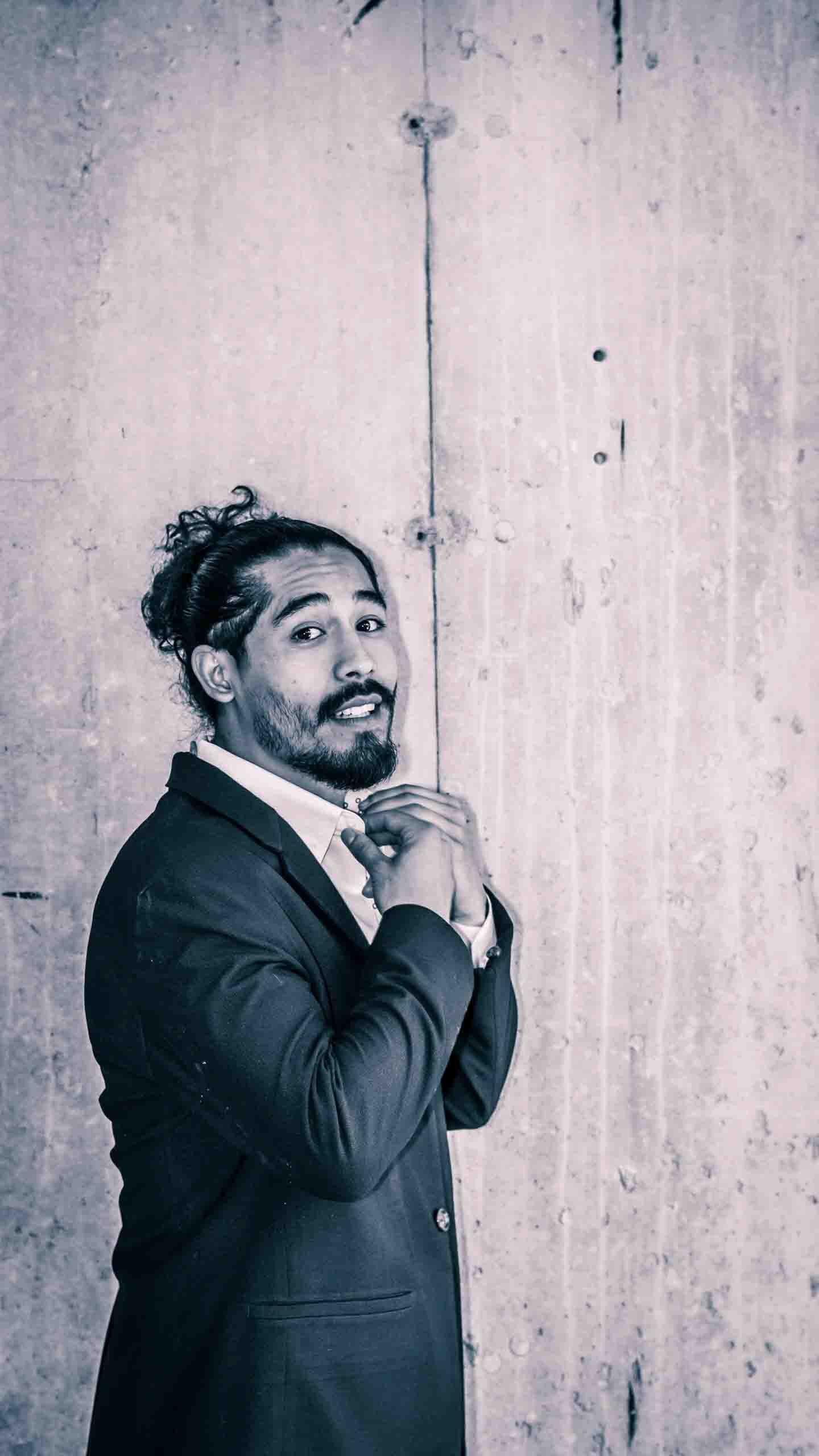 Series of black and white portraits showing playful expressions against concrete wall.