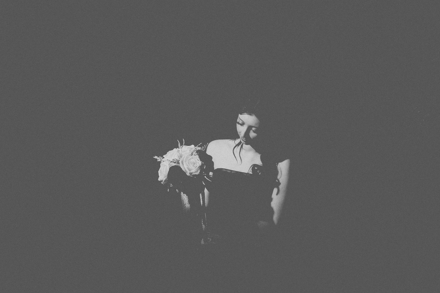 A series of white silhouettes of horses and riders arranged in a horizontal line against a dark gray background.