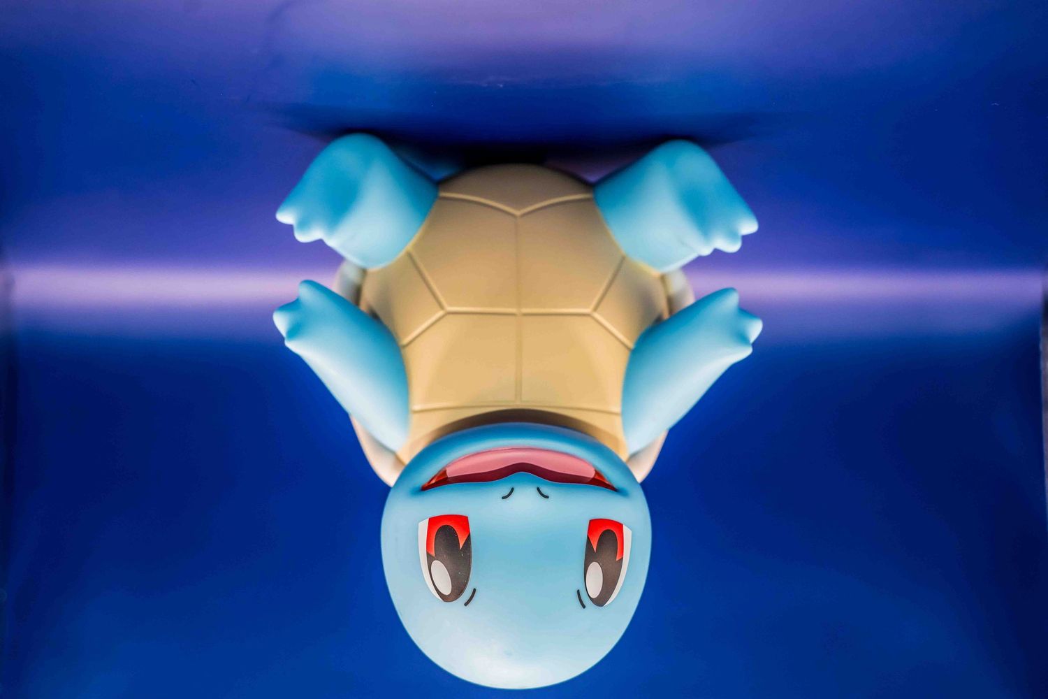 Blue Squirtle Pokemon plush toy photographed against vibrant blue background in different poses.