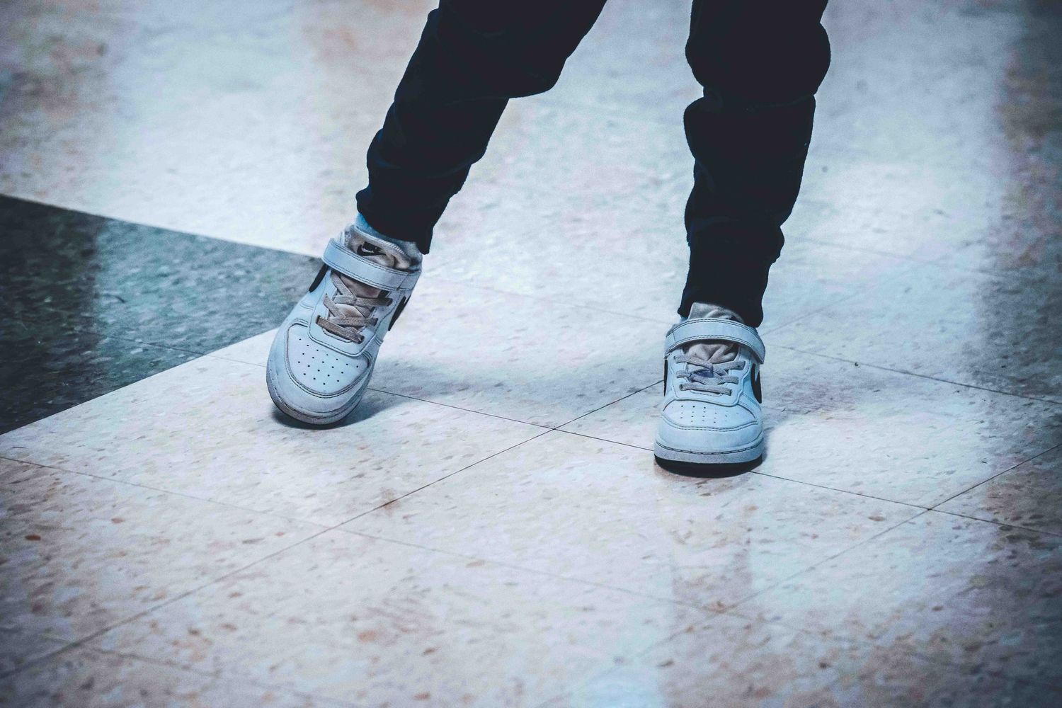 Close-up shots of various sneakers and footwear on textured floor.