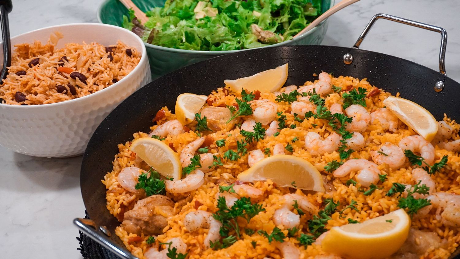 Spicy seafood rice dish garnished with herbs and lemon wedges.
