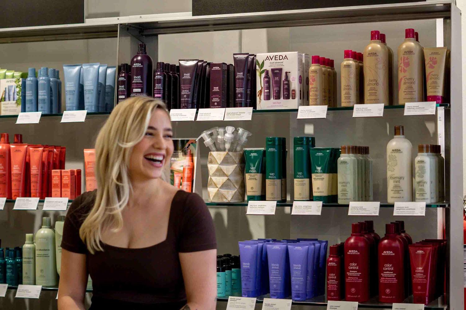 Beauty salon interior with rows of professional hair care products displayed on shelves.