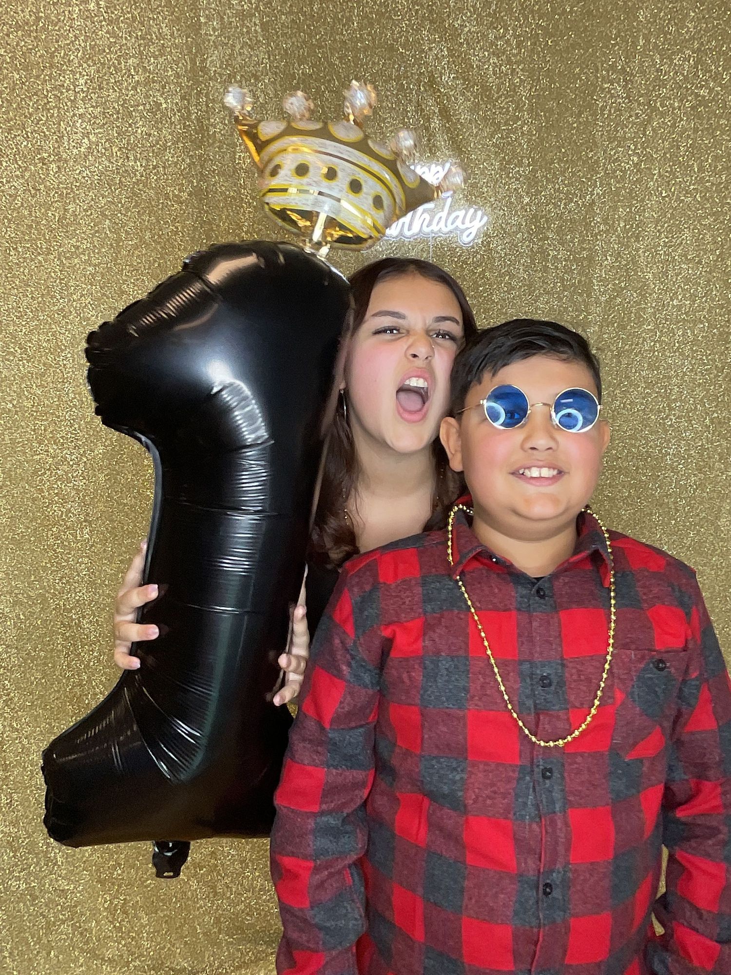 Fun photo booth sequence with red plaid shirt and black balloon props against a gold sparkly backdrop.