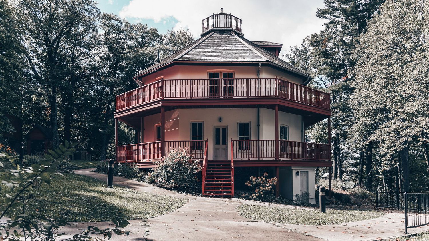 Historic lighthouse building with observation deck overlooking a scenic waterfront landscape.