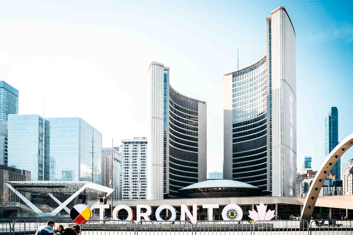 Toronto city skyline featuring modern glass buildings and iconic Toronto sign.