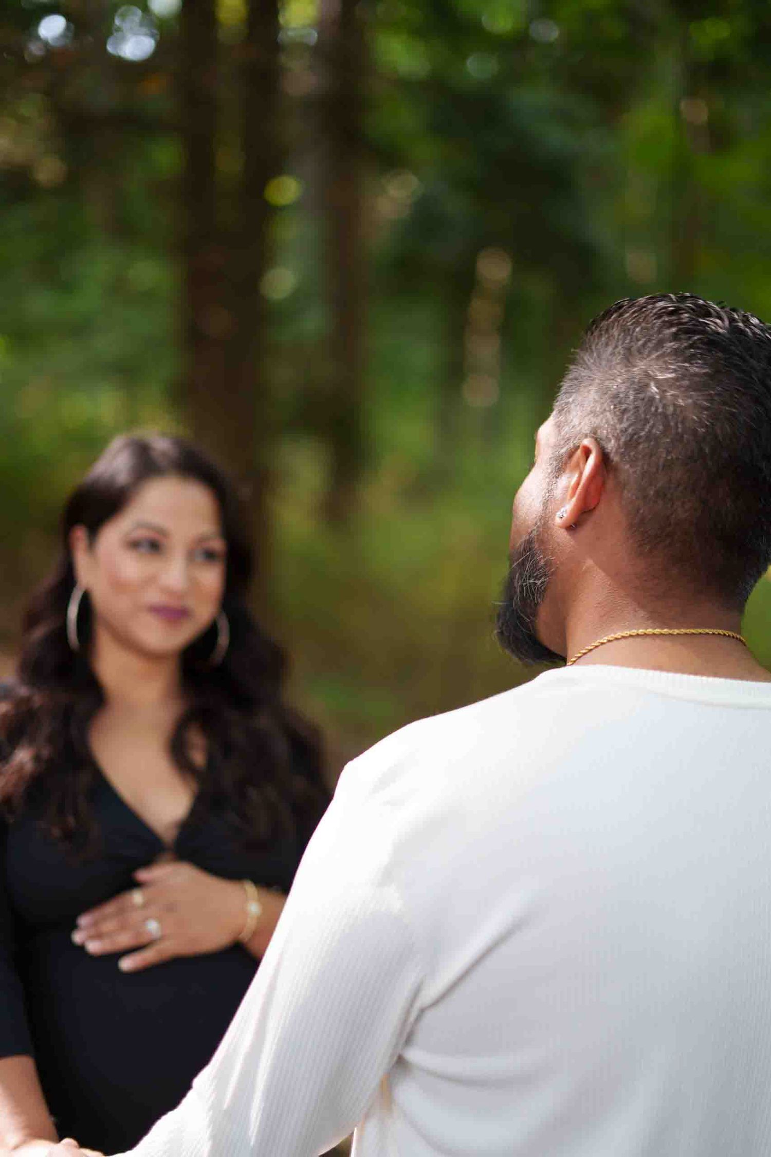 Romantic outdoor photoshoot in a wooded setting with natural bokeh.