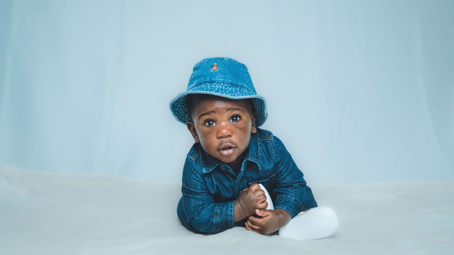 Candid moments captured in blue denim attire on a minimalist background.