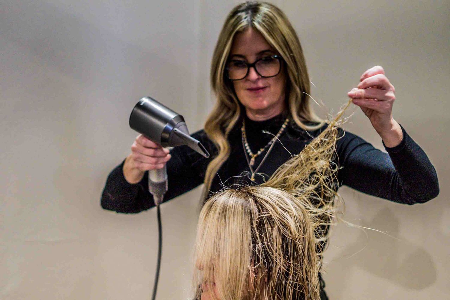 Professional hair styling session in progress at modern salon studio.