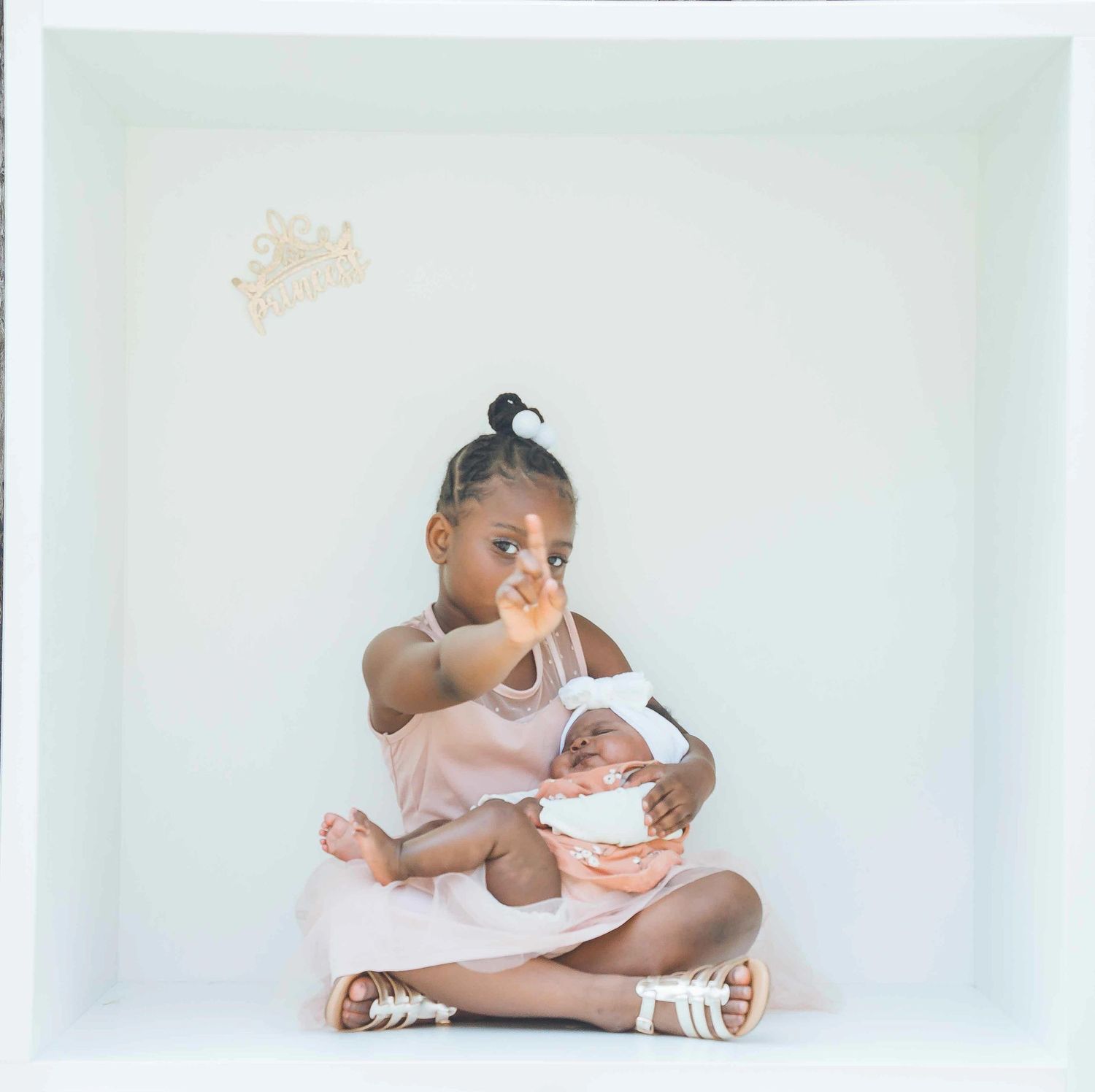 Series of intimate family moments captured in a minimalist white studio setting.