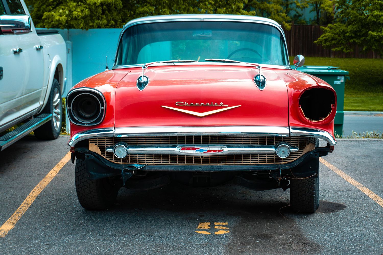 Front and rear views of classic 1950s cars showing distinctive chrome details and tail fins.