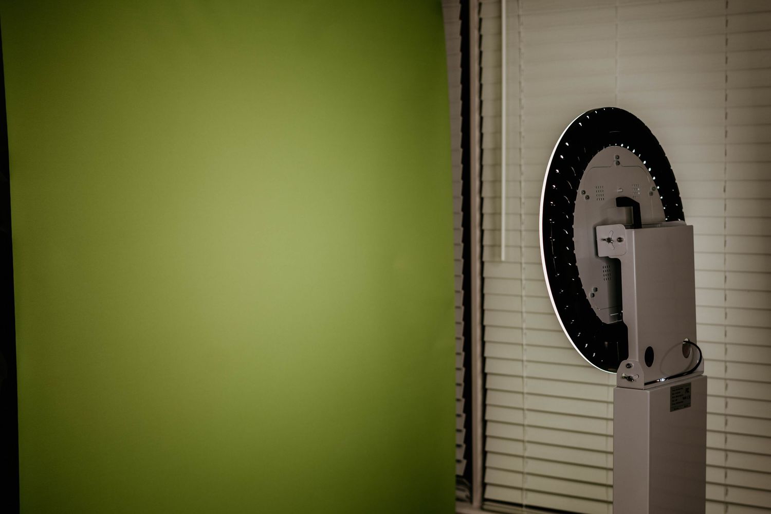 Illuminated circular light fixture mounted above digital display in dark setting.