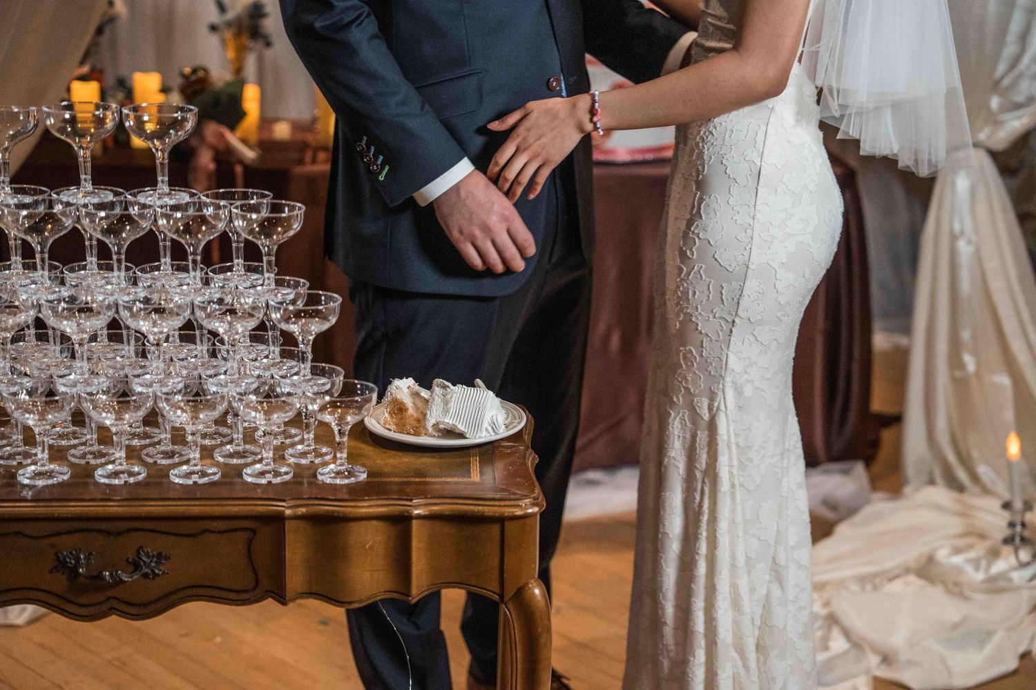 Elegant wedding reception setup with champagne glasses on wooden table and formal attire.