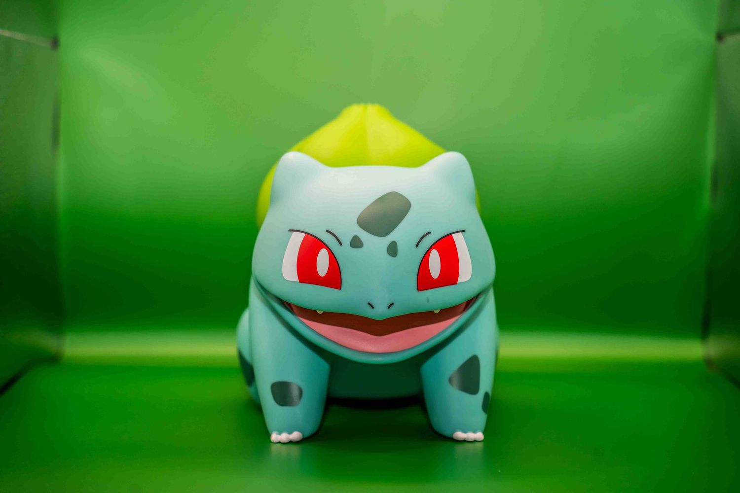 Bulbasaur Pokemon toy figure displayed on bright green background.