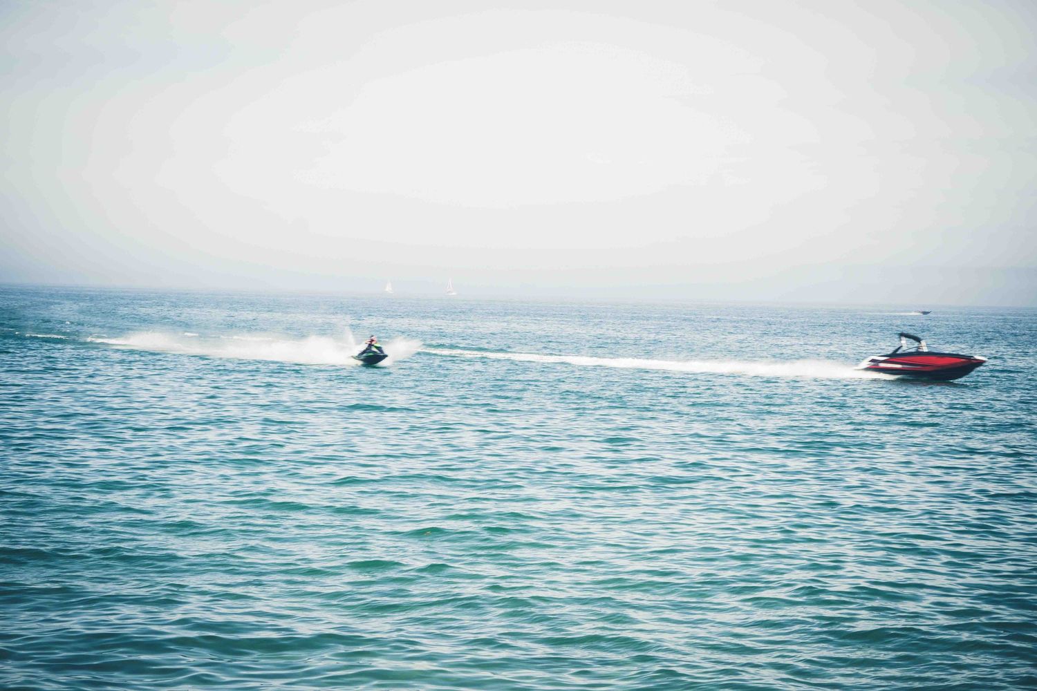 Scenic ocean view with jet skis riding across blue waters.