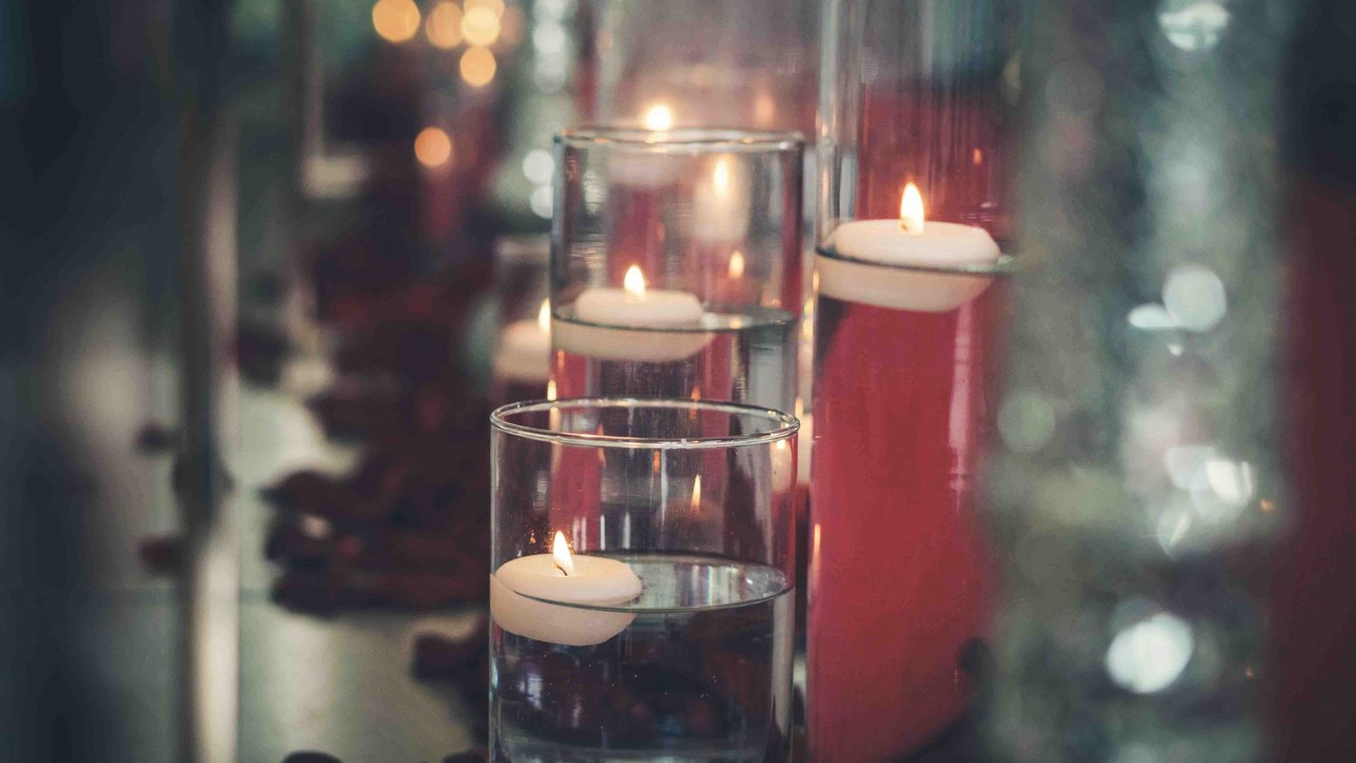 Romantic candlelit table settings with glowing votives creating ambient lighting.