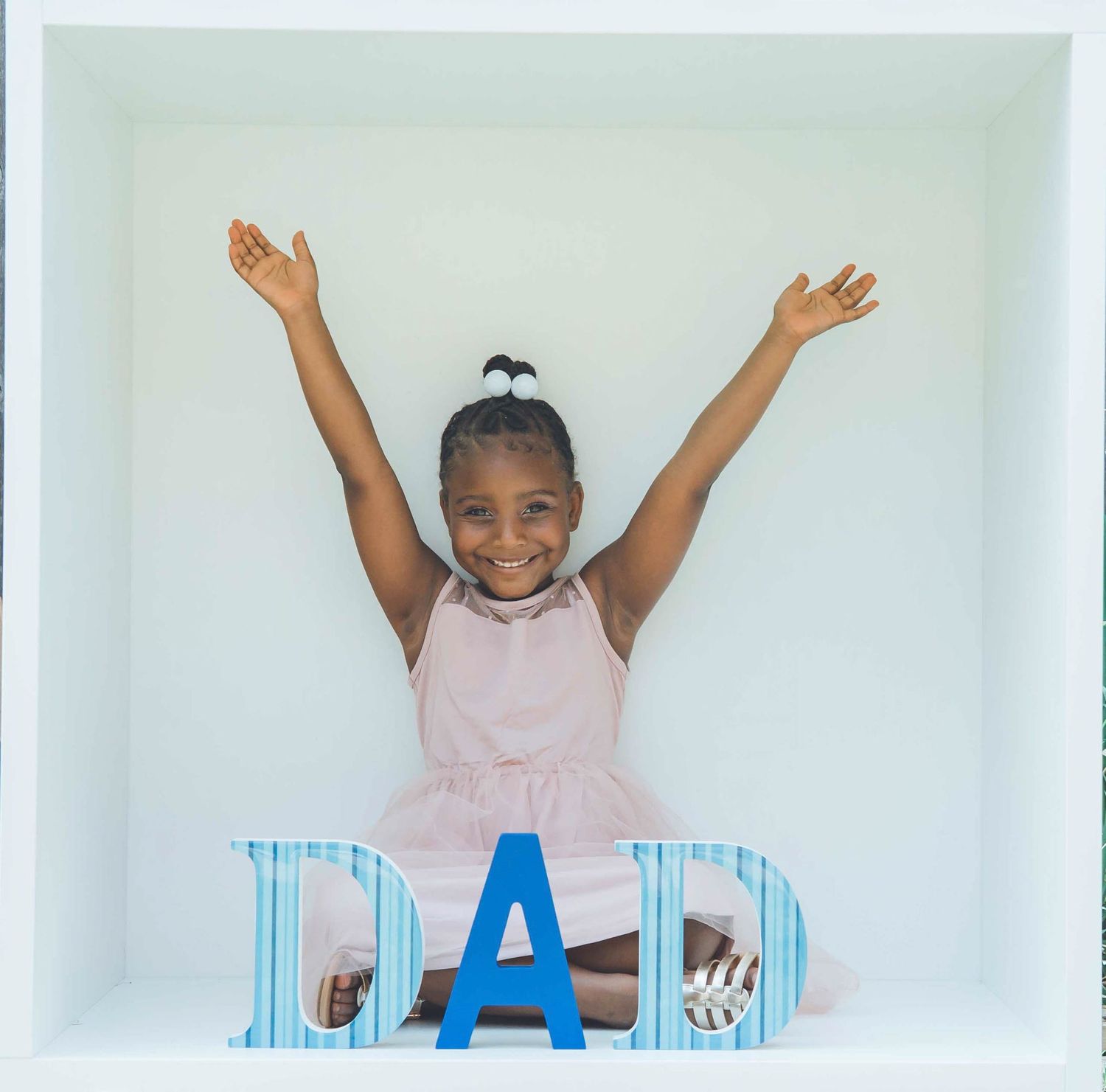 White photo studio setup with blue striped letters spelling DAD.
