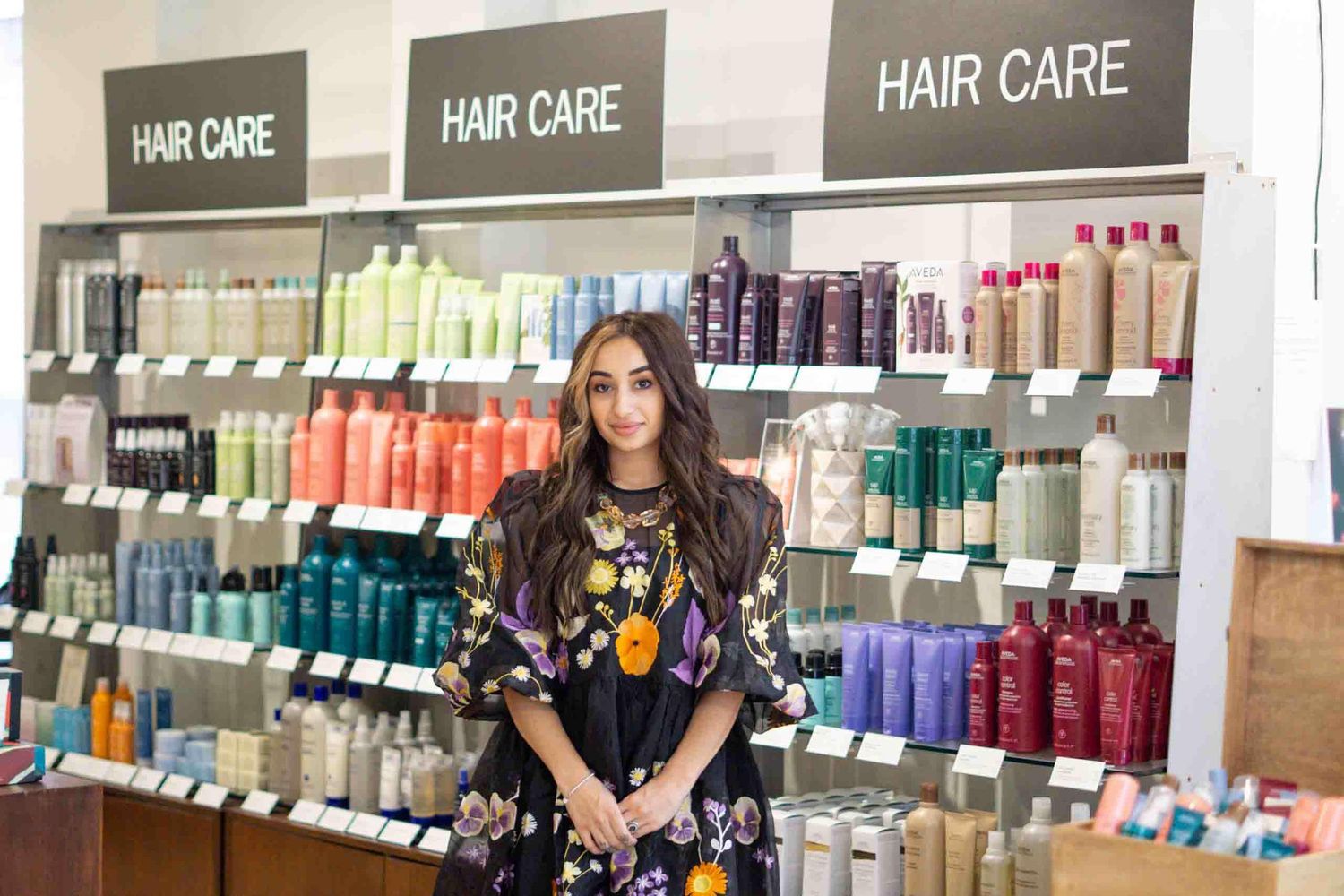 Hair care products displayed on retail shelves in a salon setting.