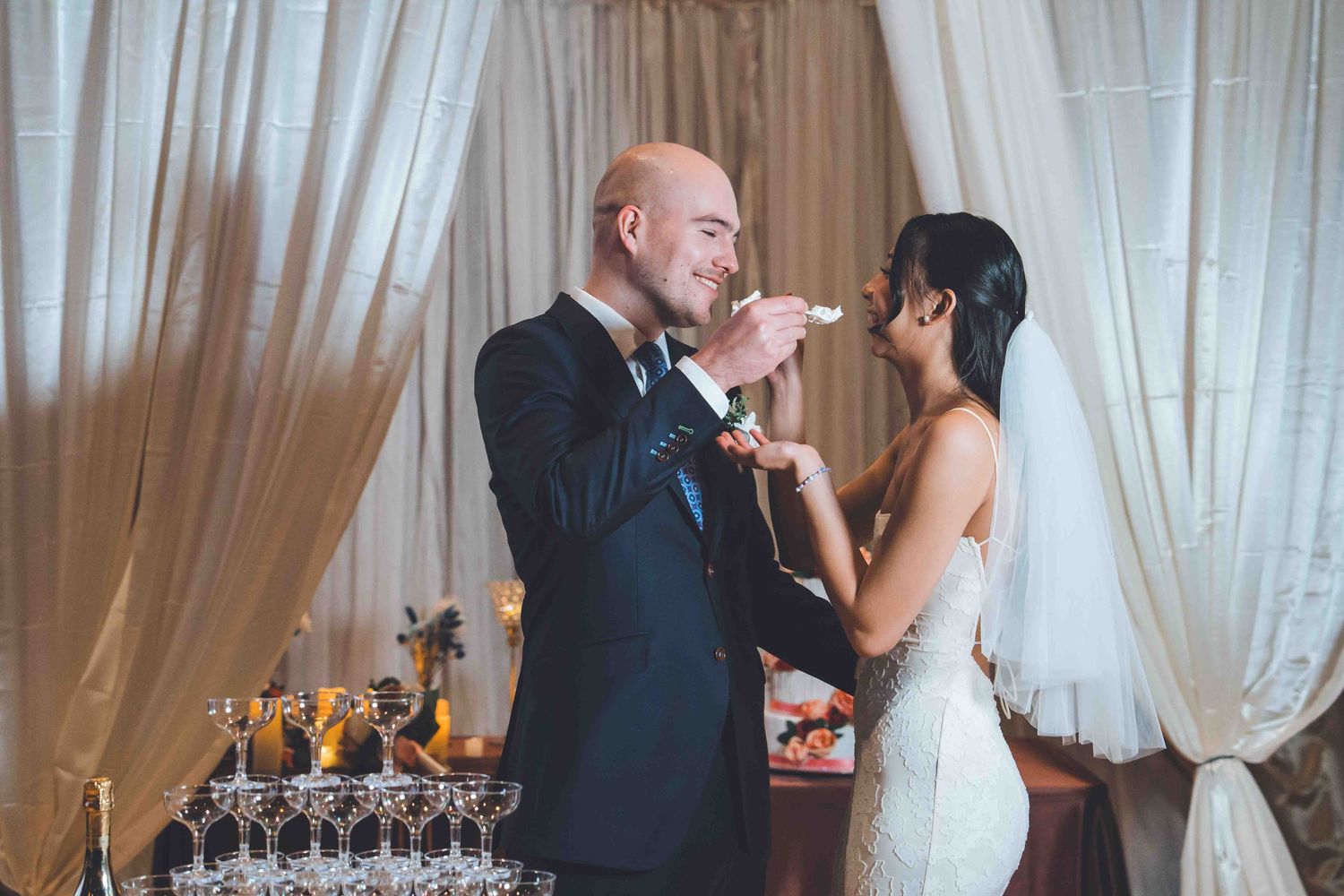 Newlyweds share their first kiss as husband and wife during an elegant indoor wedding ceremony.