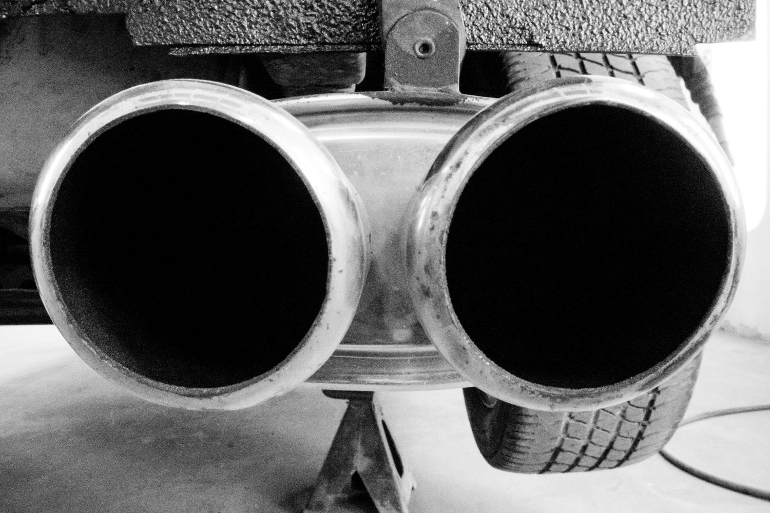 Black and white close-up of oval-shaped sunglasses creating dramatic shadows.