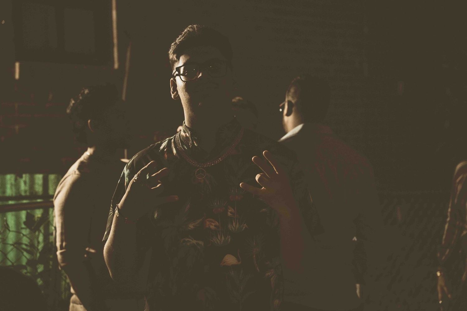 Silhouettes of people standing in dark lighting with dramatic shadows.