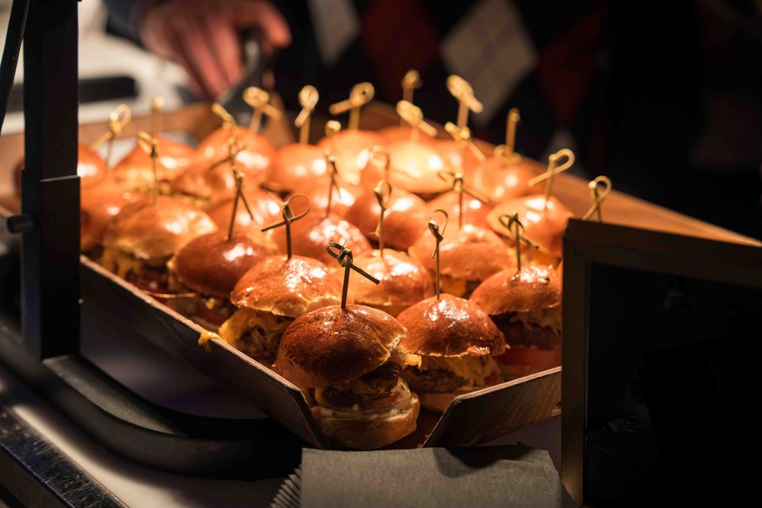 Elegantly plated appetizers with garnishes served on dark platters.