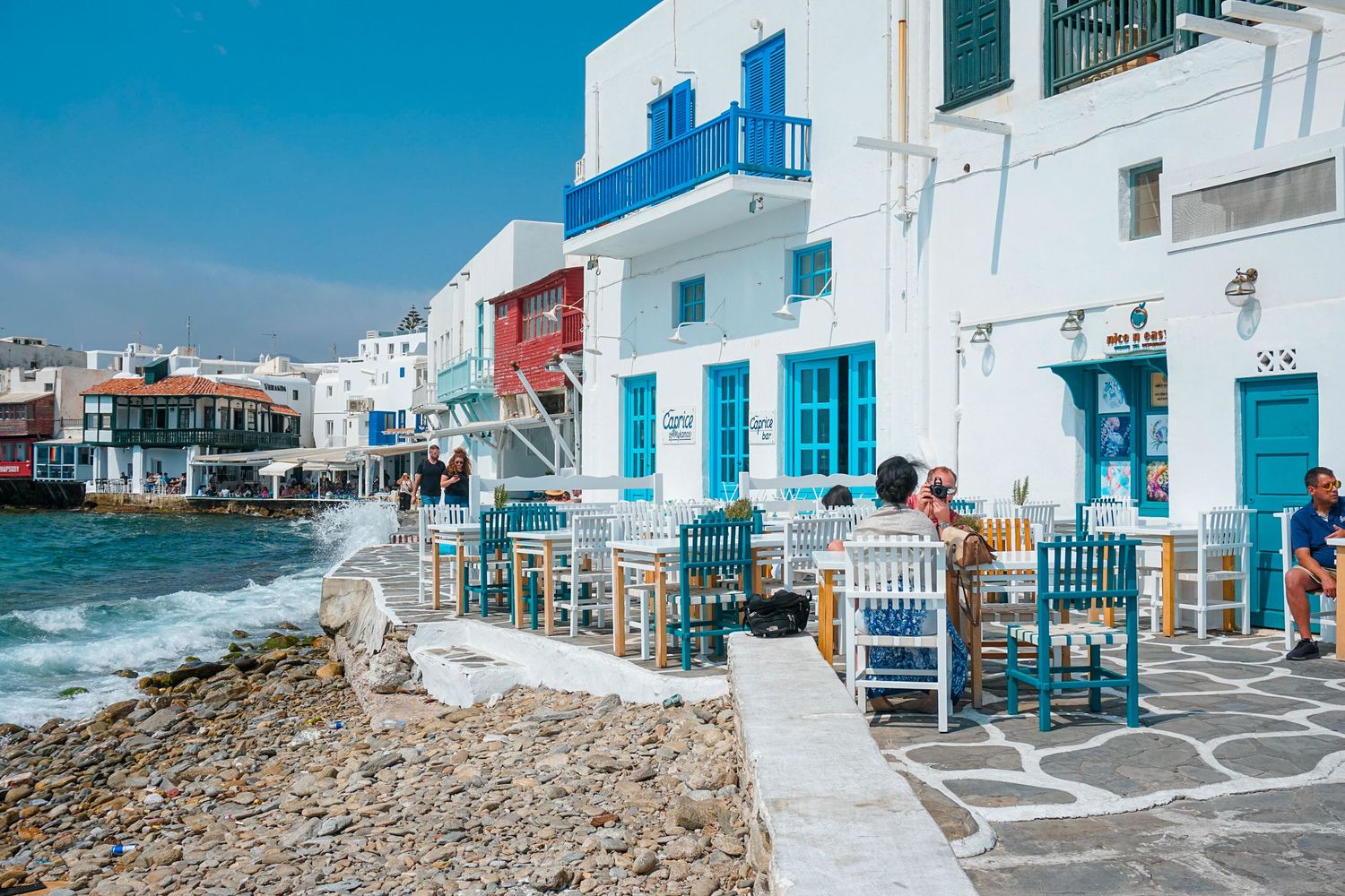 Traditional white and blue Greek island architecture with seaside views.