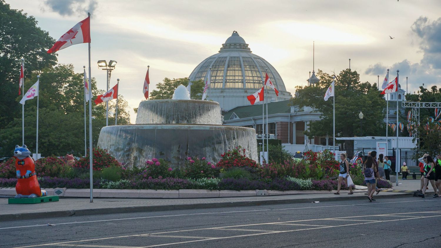Panoramic view of city buildings with domed architecture and flags.