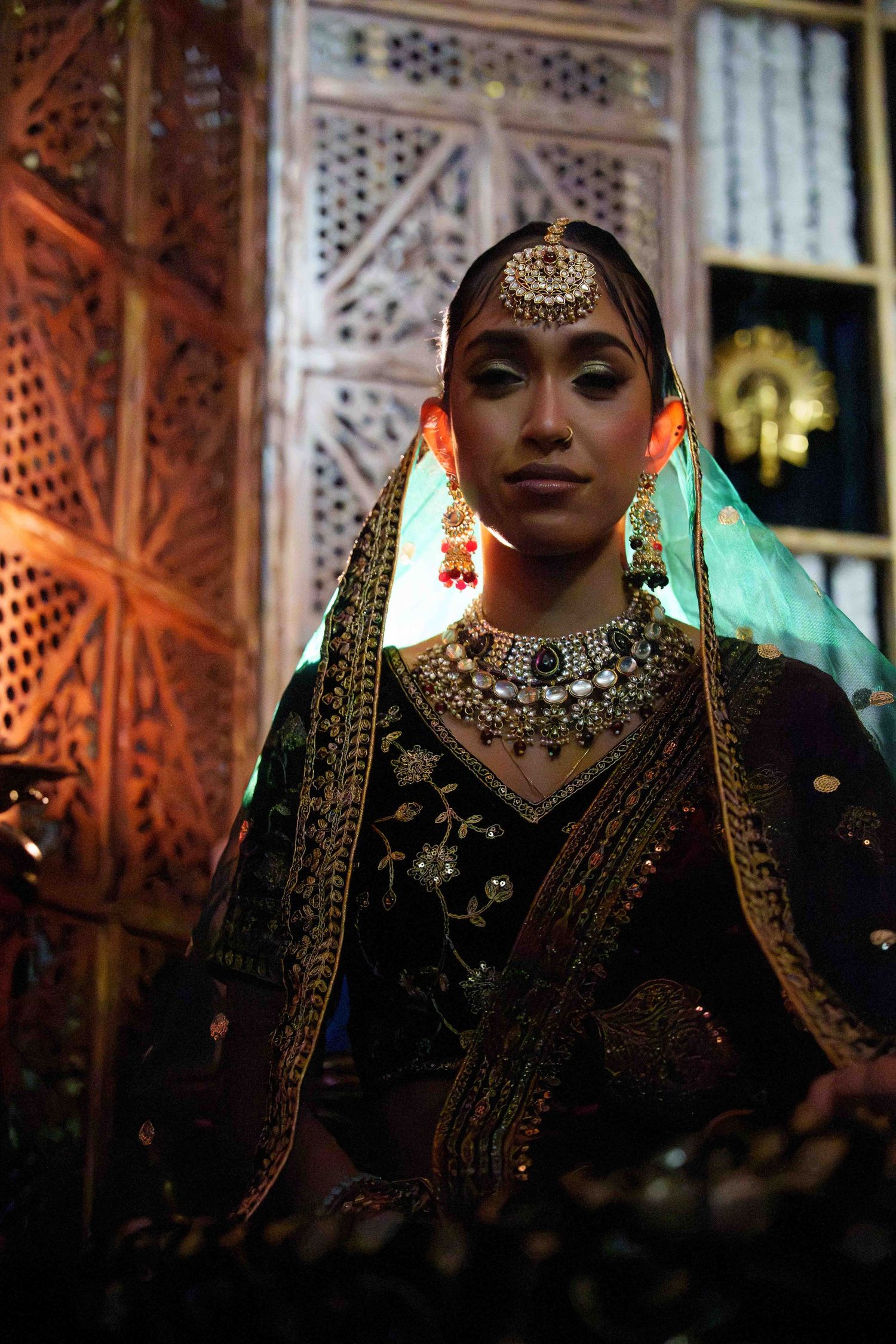 Traditional Indian bridal jewelry and attire shown in a series of atmospheric dark portraits with ornate architectural details.